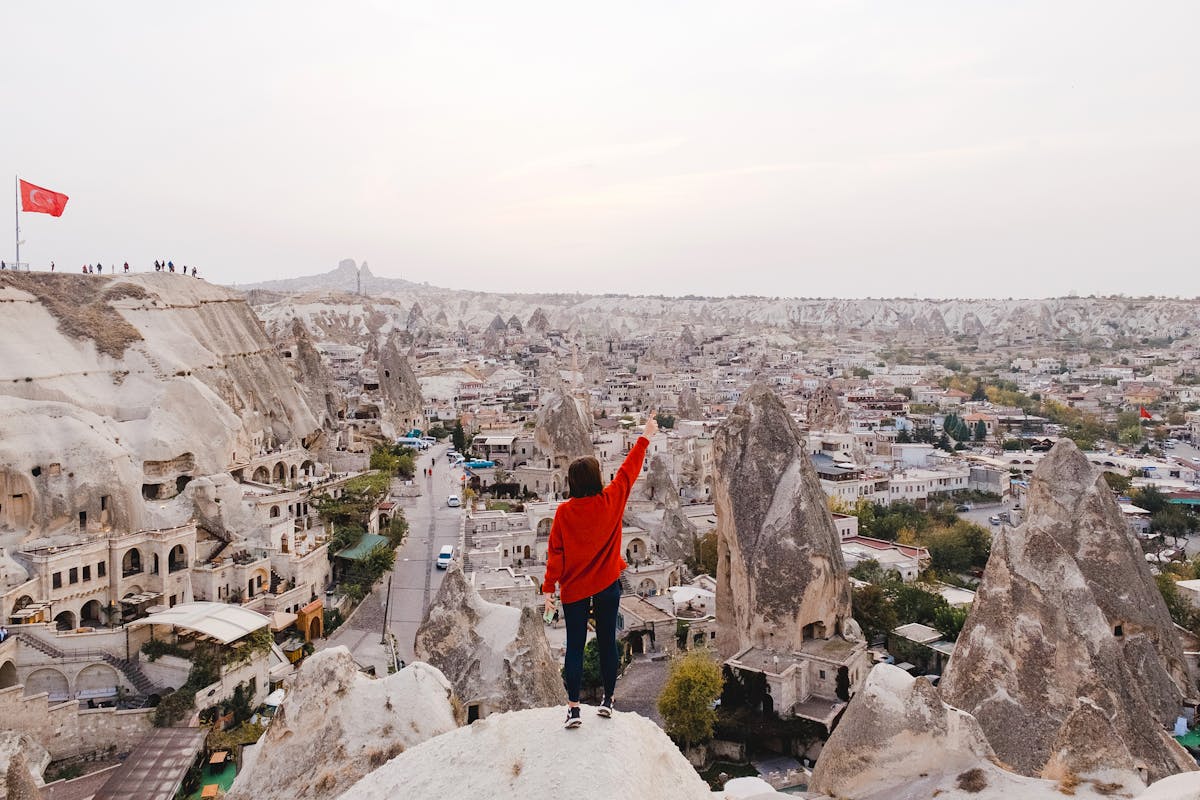 Dozens of balloons over rocky landscape in Goreme